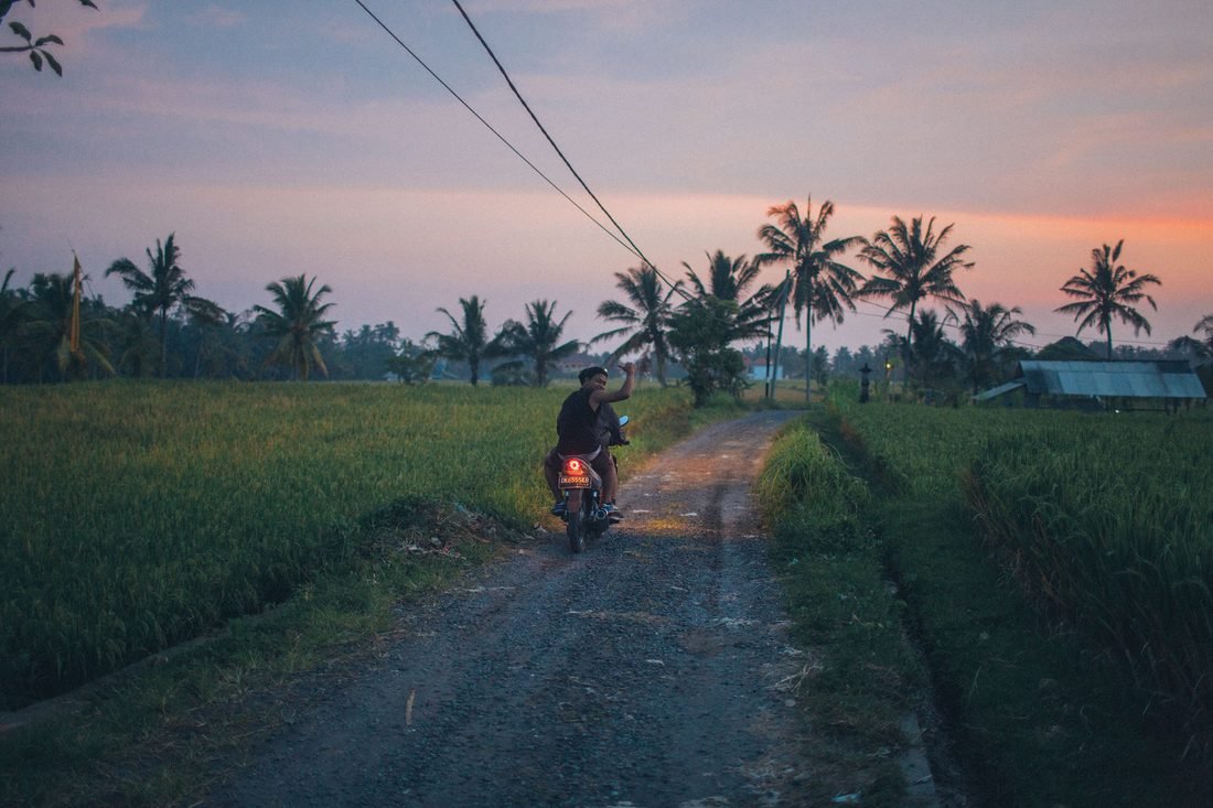 A motorbike on a lane between rice fields at dusk, Bali
